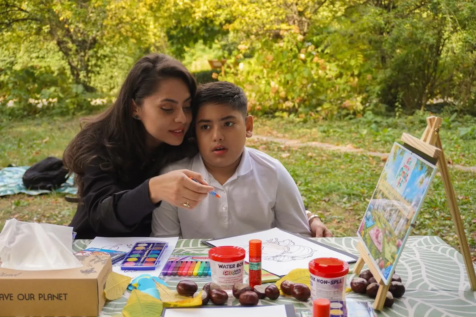 Mama și copilul pictează împreună la atelierul în parc