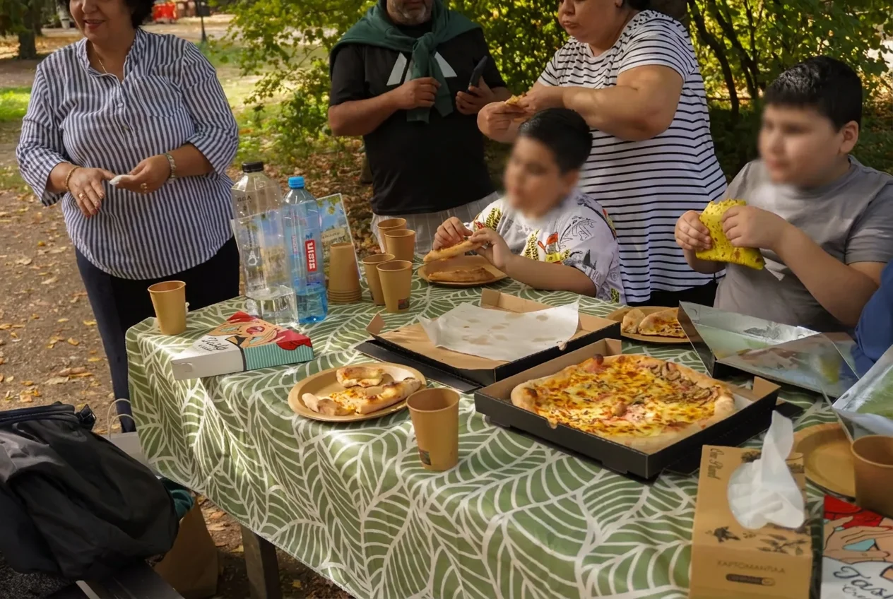 Copii și părinți la masă, împărțind pizza